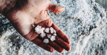 Man holding sea salt in his hand for adding salt to your Aquaponics System
