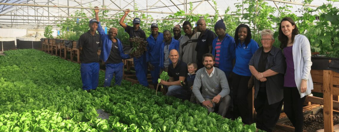 The team standing next to a deep water culture aquaponic setup