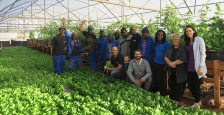 The team standing next to a deep water culture aquaponic setup